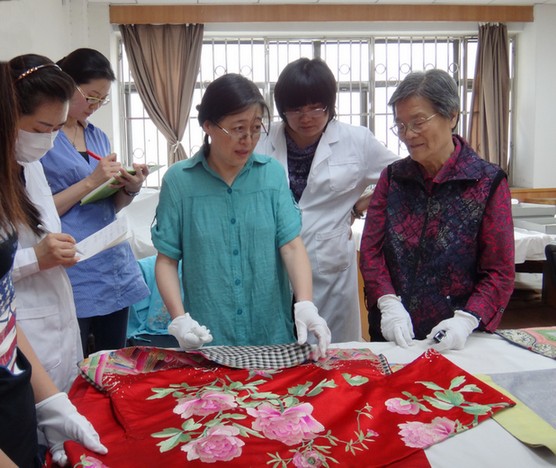 研究人员观察中国传统刺绣实物
